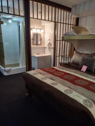 a bedroom with a bed and a bathroom with a sink at The King George Inn in Cobourg