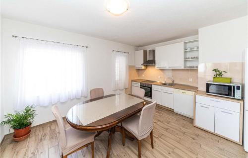 a kitchen with a table and chairs in a room at Amazing Apartment In Kastel Stari in Kastel Stari