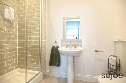 a bathroom with a sink and a shower at Newly refurbished studio with harbour views in Lowestoft