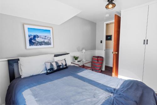 een slaapkamer met een groot bed en een blauwe deken bij Dream Street Escape -Private Hot Tub, near the Village and Lake! in Big Bear Lake