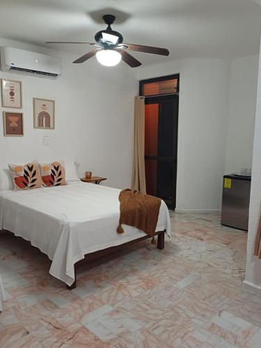 a bedroom with a bed and a ceiling fan at Casa Las Palmas in Cancún