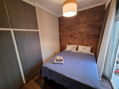um quarto com uma cama azul com toalhas em Όμορφο διαμέρισμα στο κέντρο της πόλης em Serres