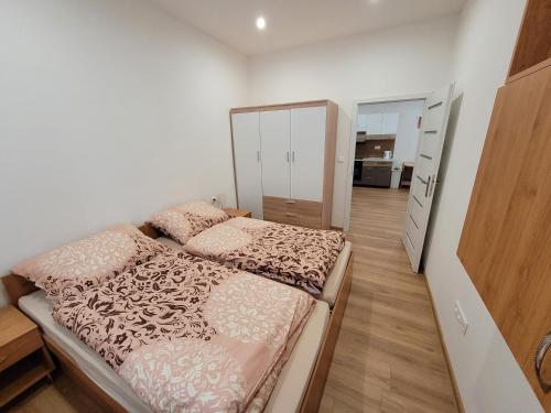 a small bedroom with a bed and a mirror at Apartman Tailor in Liptovský Mikuláš
