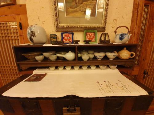 a room with a table with bowls and vases on a shelf at Hanok Moryeon in Jeonju