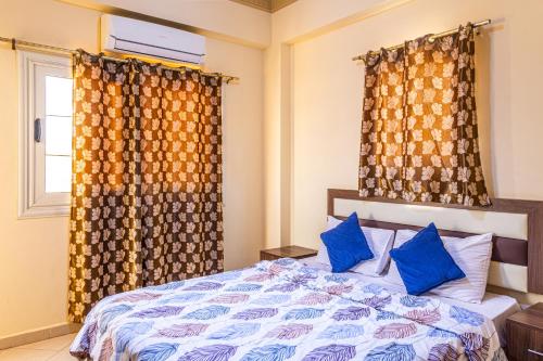 a bedroom with a bed with blue pillows and a window at lucky house Dahab in Dahab