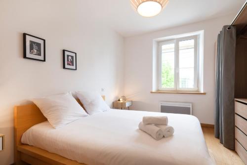 a bedroom with a white bed with a towel on it at La Terrasse Du Gibet in Montigny-lès-Metz