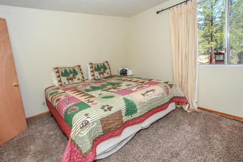 een slaapkamer met een bed en een raam bij Little Brown Bear - Beautiful view, quiet area and an amazing hot tub! in Big Bear Lake