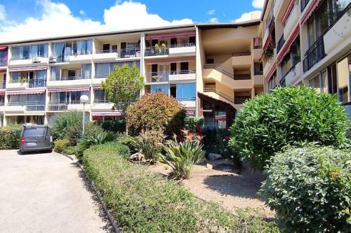 un immeuble avec une voiture garée devant lui dans l'établissement La Croisette, parking, proche plage, à La Seyne-sur-Mer