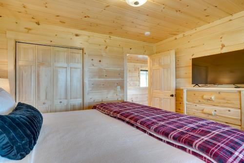 a bedroom with a bed and a flat screen tv at Gorgeous Gatlinburg Cabin Large Deck and Hot Tub! in Gatlinburg