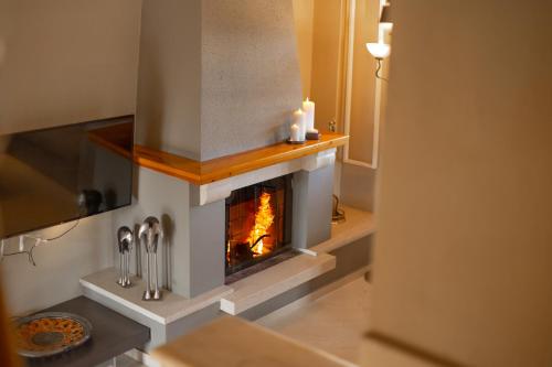 a kitchen with a fireplace with two candles on it at Villa Elisabeth in Platamonas