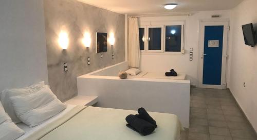 uma casa de banho com 2 camas e uma banheira em Lagada Beach Hotel em Adamas