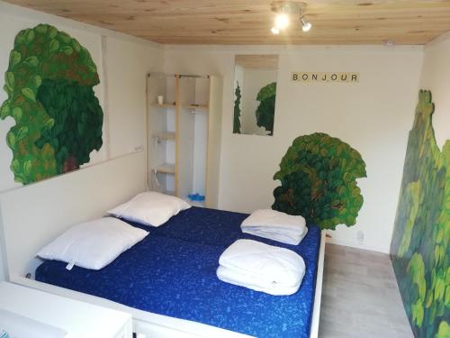 - une chambre avec un lit bleu et 2 oreillers dans l'établissement Hébergements camping 