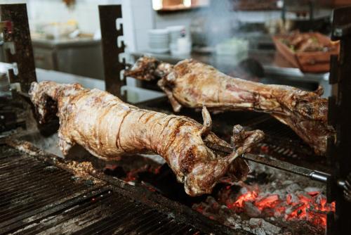 two pieces of meat cooking on a grill at Hotel Taverna Devolli in Kuçovë