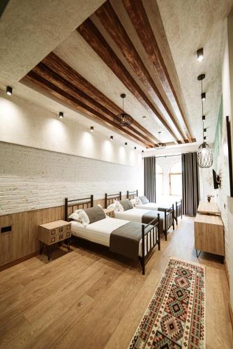 a bedroom with four beds and a rug at Hotel Taverna Devolli in Kuçovë