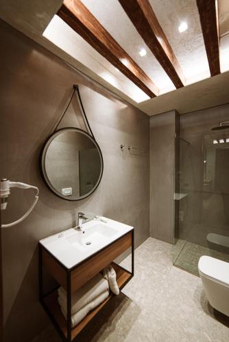 a bathroom with a sink and a mirror and a shower at Hotel Taverna Devolli in Kuçovë