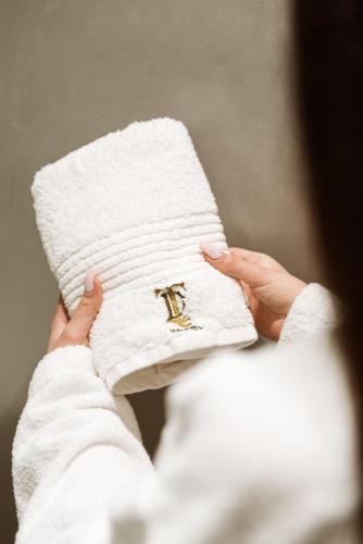 a hand holding a white pillow with a letter on it at Hotel Taverna Devolli in Kuçovë