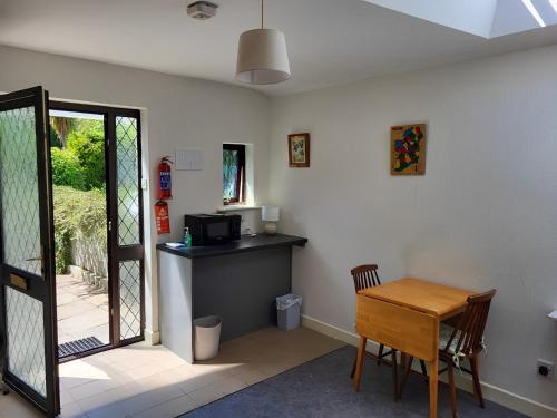ein Wohnzimmer mit einem Tisch und einer Mikrowelle in der Unterkunft Oak Cottage 3 km from Rock of Cashel in Cashel