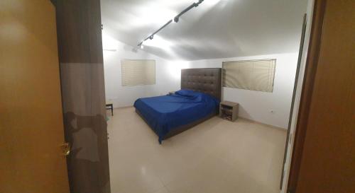 um quarto com uma cama azul num quarto branco em Gruda Apartments em Shkodër
