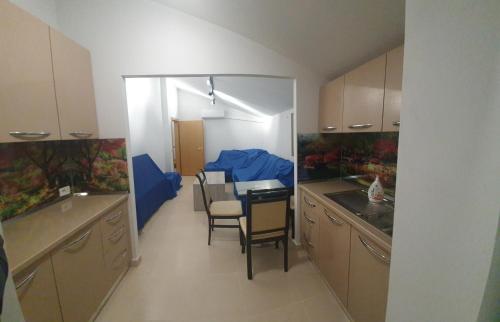 uma pequena cozinha com mesa e cadeiras em Gruda Apartments em Shkodër