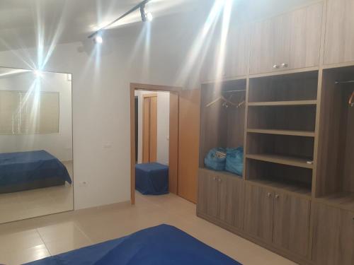 a bedroom with a mirror and a blue rug at Gruda Apartments in Shkodër