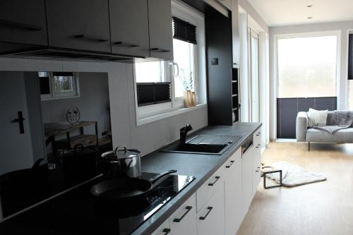 a kitchen with a black counter top and a sink at Ferienhaus Aurora, Sauna, familienfreundlich, angeln in Twist