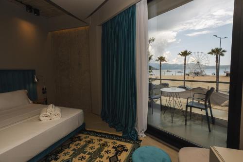 a bedroom with a large window with a view of the beach at Dot Tradition in Vlorë