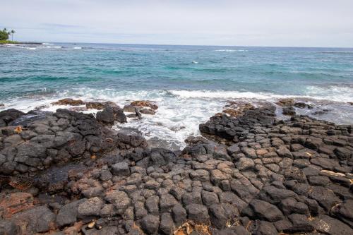 Kukuiula的住宿－Kuhio Shores 107，海洋和岩石在水中的形象