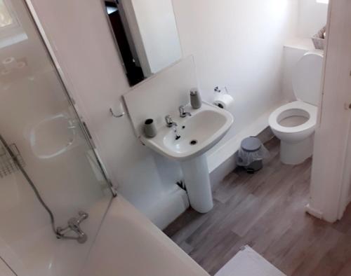 a white bathroom with a sink and a toilet at Thorpe Place in Hawthorn