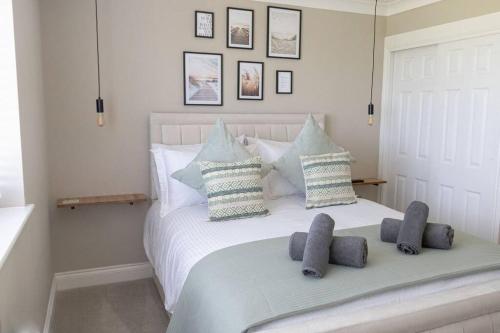 a bedroom with a white bed with pillows on it at The Rosewood, Cornwall. in Roche