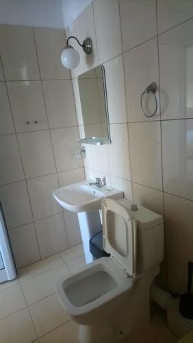a bathroom with a sink and a toilet and a mirror at Vergina Pension in Sarti