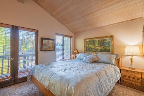 a bedroom with a bed and two windows at Lakefront Viking Oasis - Beautiful Viking Estates condo complex on the lake! in Big Bear Lake