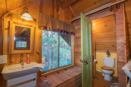 uma casa de banho com um lavatório, um WC e uma janela. em Far Enough Cabin - Chalet style cabin, walking distance to the trails! Foosball table! em Sugarloaf