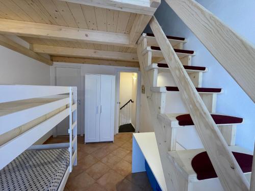 a room with stairs leading up to a loft at Casa Chiocciola Eleonora in SantʼAntìoco