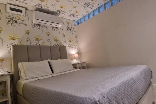 a bedroom with a bed with flowers on the wall at Casa de Férias_As Oliveiras I in Espinho