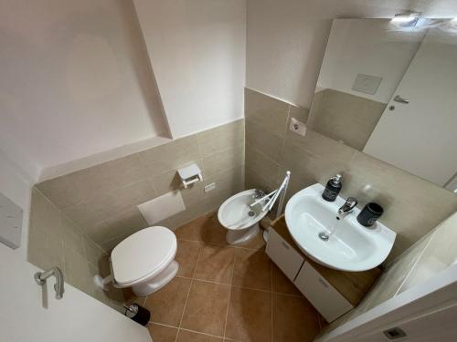 a bathroom with a white toilet and a sink at Casa Chiocciola Eleonora in SantʼAntìoco