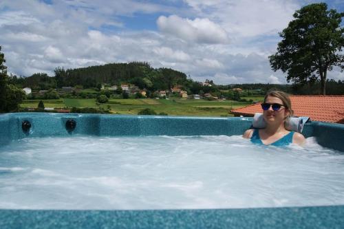 una mujer en un jacuzzi en una piscina en Casa de Busto en Zas