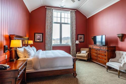 Schlafzimmer mit roten Wänden, einem Bett und einem Fenster in der Unterkunft The Inn at Cobble Beach in Kemble