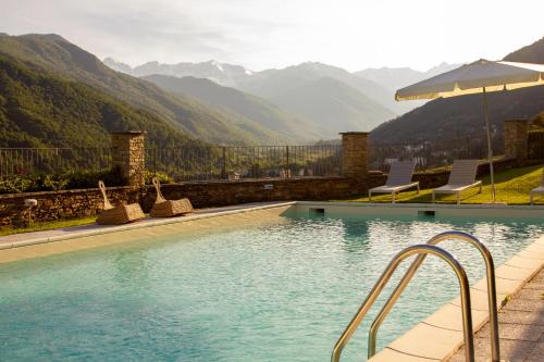 a swimming pool with a view of mountains at Cascina del Forte in Torre Pellice