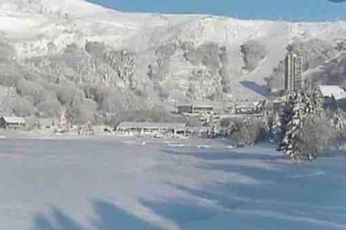a frozen lake with a mountain in the background at Appartement Dans un village en Auvergne sancy in Égliseneuve-dʼEntraigues