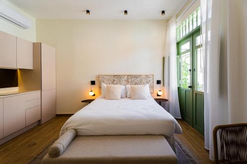 um quarto com uma cama grande e uma porta verde em AmazINN Places Deluxe Estudio Casa Marichu Casco Viejo na Cidade do Panamá