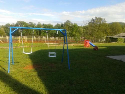 a park with a swing set in the grass at B&B Nikki in Međugorje