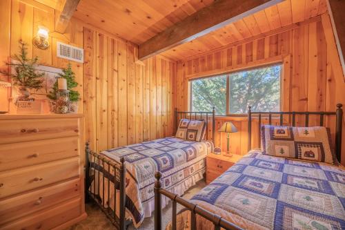 a bedroom with two beds in a log cabin at Fawnskin Family Cabin - Nicely decorated cabin with a lake view and a Foosball Table! in Fawnskin