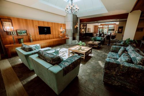un ampio soggiorno con divani e televisore di Serra Alta Hotel a São Bento do Sul