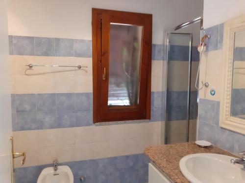 een badkamer met een wastafel, een toilet en een spiegel bij Villetta Rocchi - Costa Paradiso in Costa Paradiso