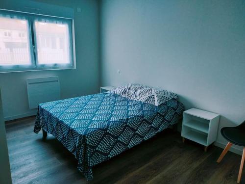 une chambre avec un lit avec une couette bleue et blanche dans l'établissement Maison agréable - 9 pers - St Hilaire de Riez, à Saint-Hilaire-de-Riez