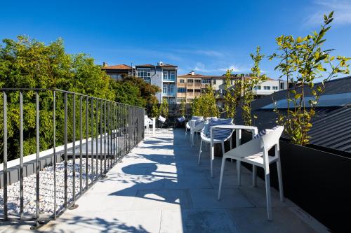 a row of chairs and tables on a balcony at Gallery Hostel in Porto