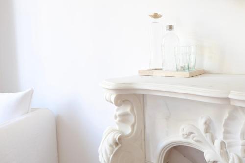 a white table with a bottle on top of it at La Bâtisse en Blanc in Golfe-Juan