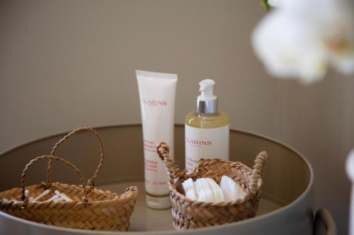 a table with two baskets and a bottle of soap at La Bâtisse en Blanc in Golfe-Juan