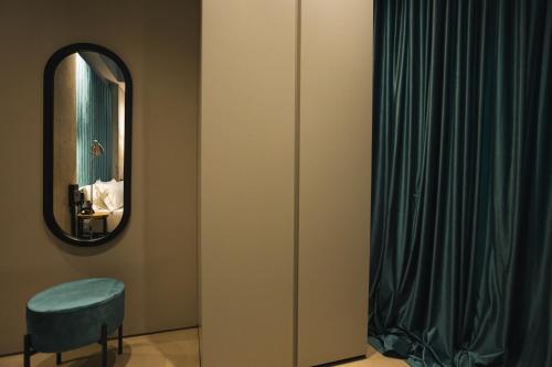 a bathroom with a mirror and a blue chair at Dot Tradition in Vlorë