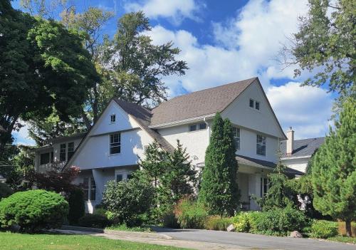 a white house with trees and bushes at Historic Oak Park Residence in Oak Park